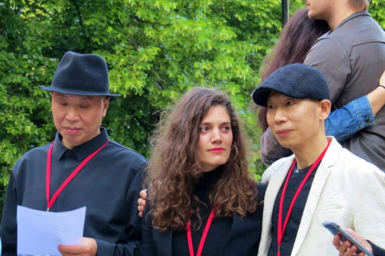 Gao Zhen und Gao Qiang stehen während ihrer Performance Utopia of the Embrace 2019 in Oslo neben Dagmar Carnevale Lavezzoli.