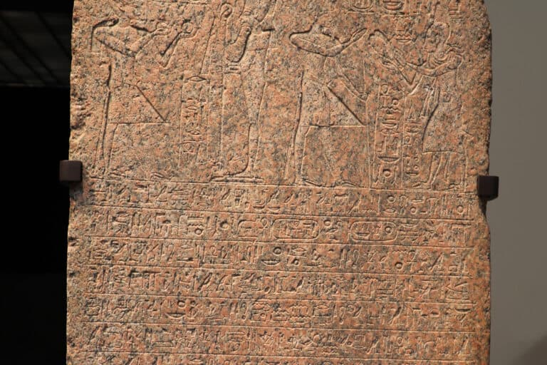 Eine rosafarbene Granitstele mit eingemeißelten altägyptischen Figuren und Hieroglyphen im Louvre Abu Dhabi.