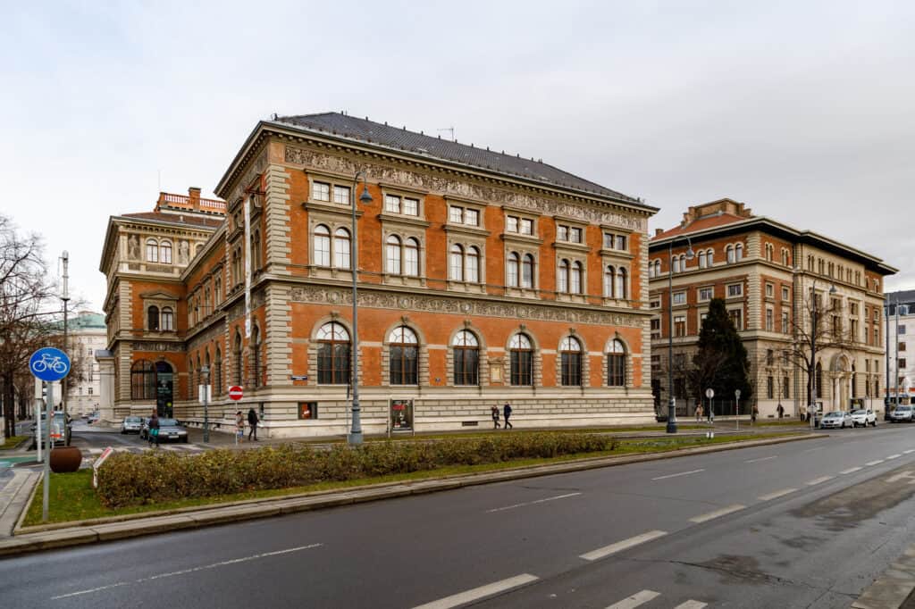 Die helle Fassade des MAK am Wiener Stubenring mit Bäumen und dem breiten Eingangsportal.