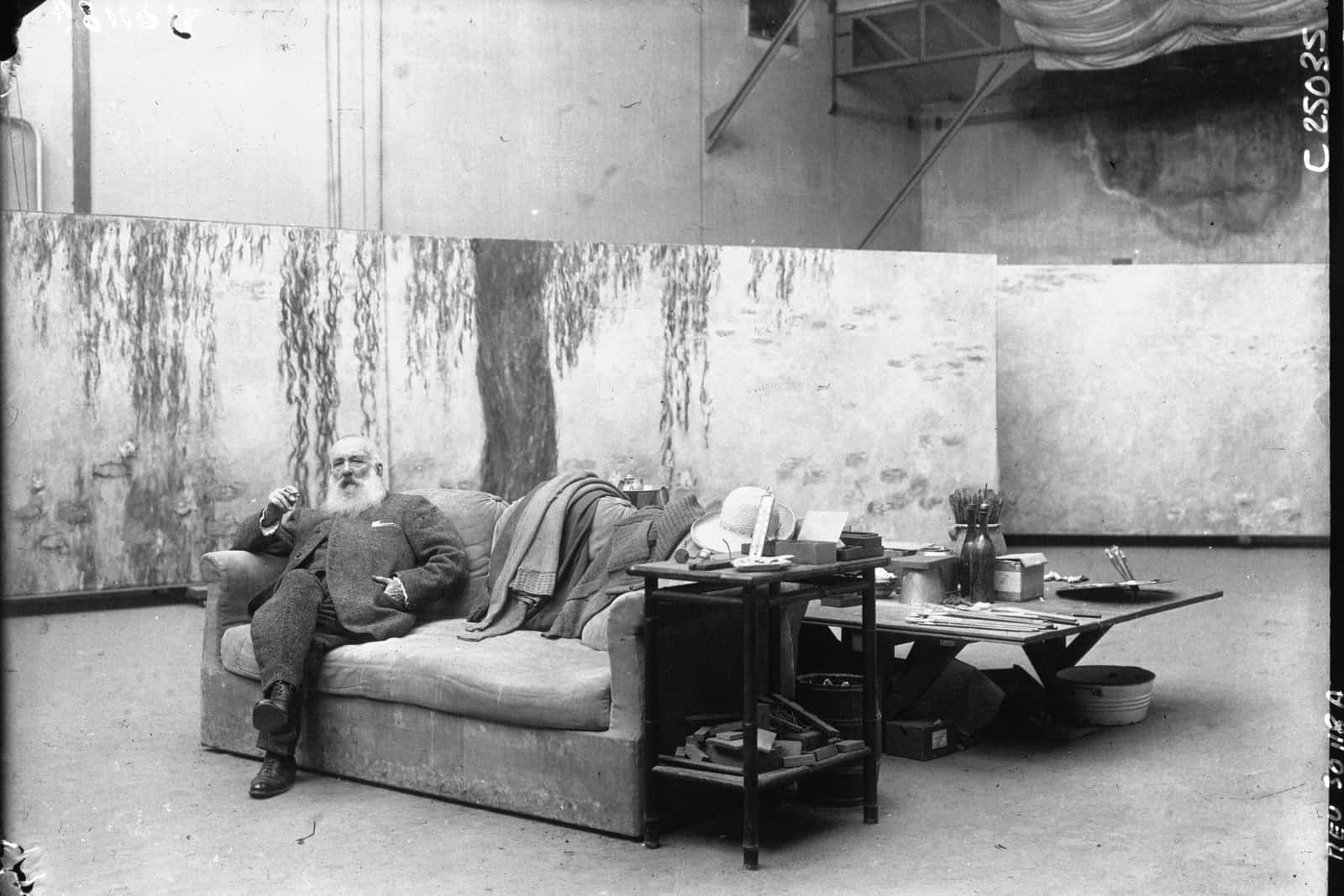 Claude Monet steht auf einer Pressefotografie von 1926 zwischen monumentalen Leinwänden in seinem Atelier.