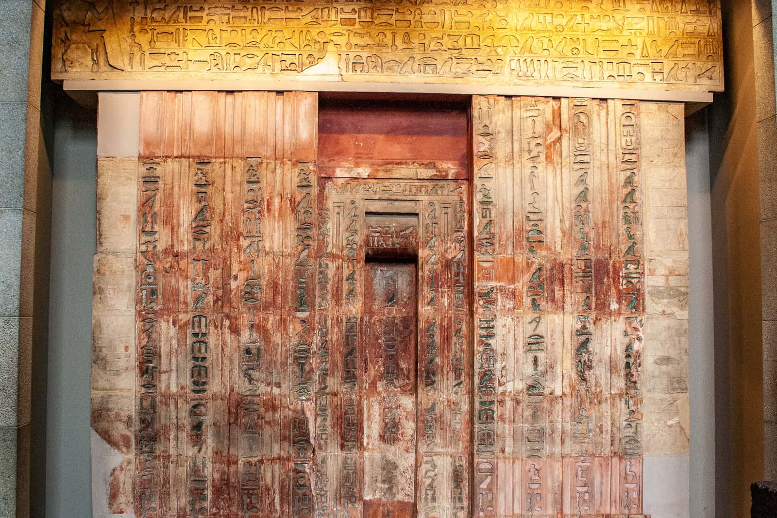 Die Scheintür und der Architrav des Ptahschepses aus Kalkstein sind mit Hieroglyphen und Opferbildern bedeckt; Spuren farbiger Bemalung sind erhalten.