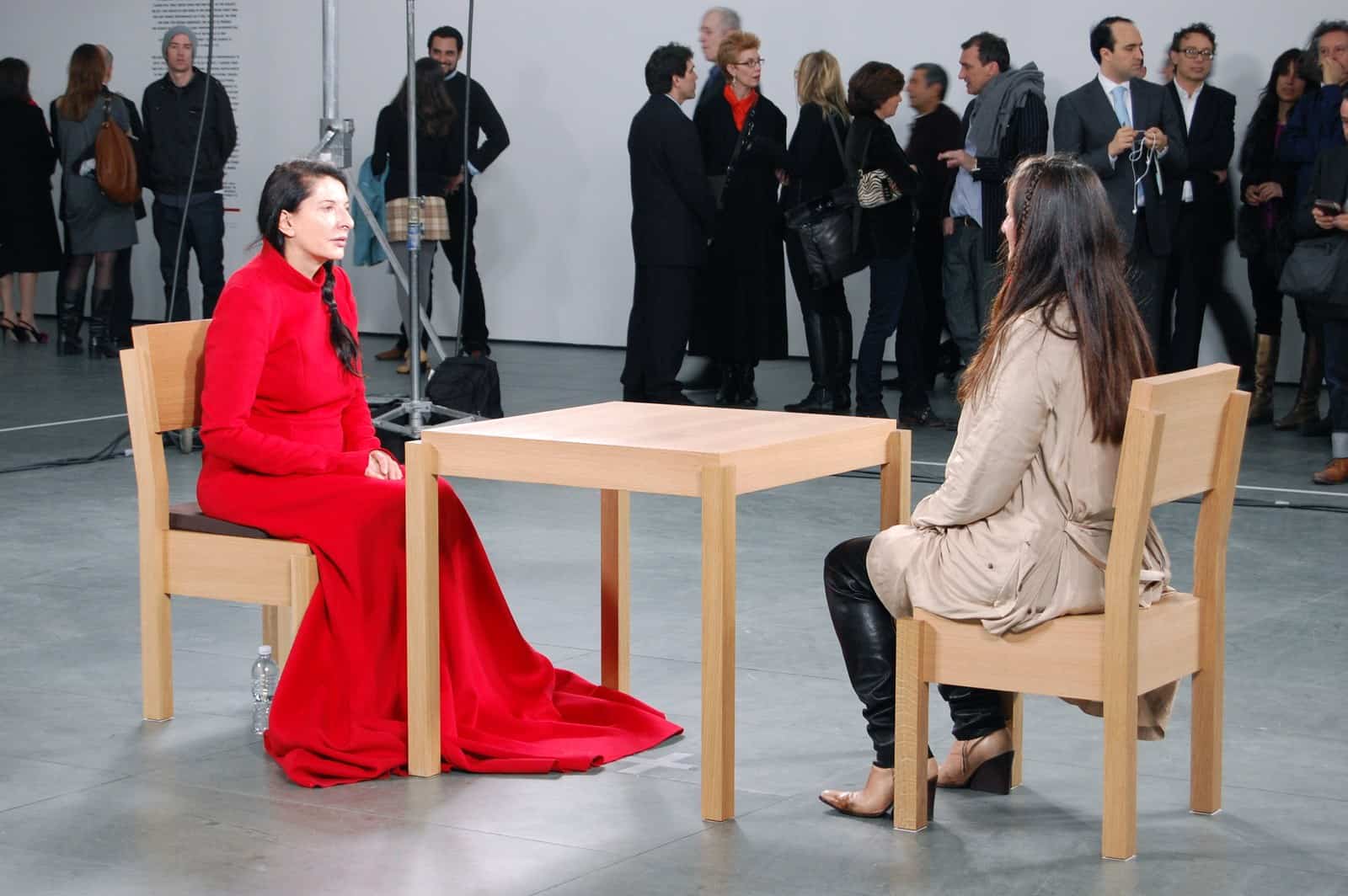 Marina Abramović sitzt bei The Artist Is Present im MoMA einer Besucherin oder einem Besucher schweigend gegenüber.