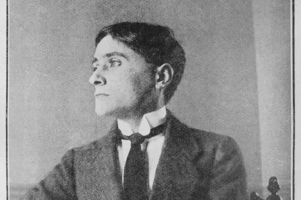 Ein schwarz-weißes Porträt von 1913 zeigt den kubistischen Maler Jean Metzinger in einem dunklen Anzug.