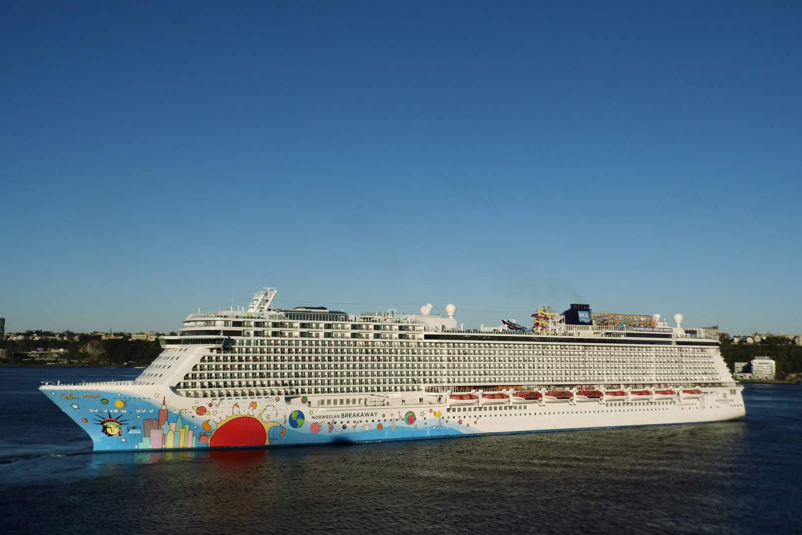 Das Kreuzfahrtschiff Norwegian Breakaway mit farbiger Rumpfgestaltung von Peter Max liegt vor Manhattan.
